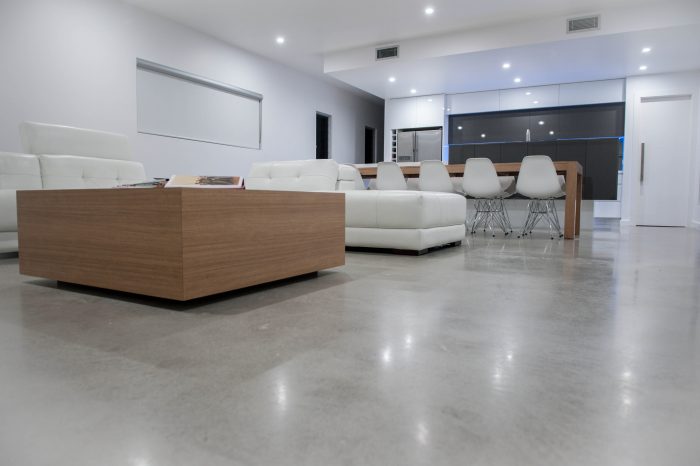 A modern living room with flooring made of concrete.