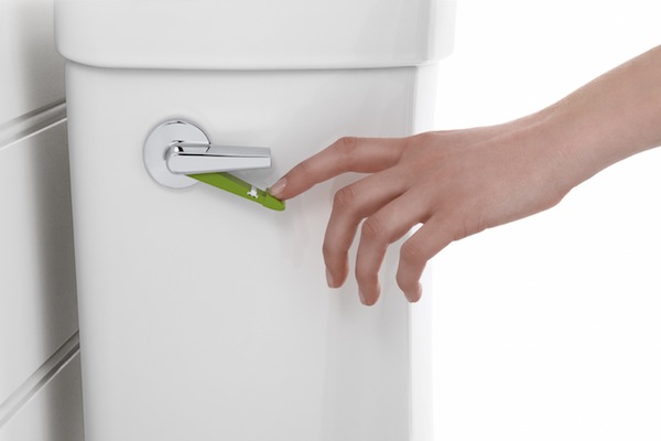 A person is holding a green handle on a toilet, symbolizing Earth-friendly practices.