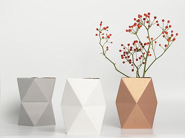 A faceted vase with a flower in it.