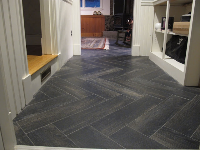 A hallway with a herringbone tile flooring.