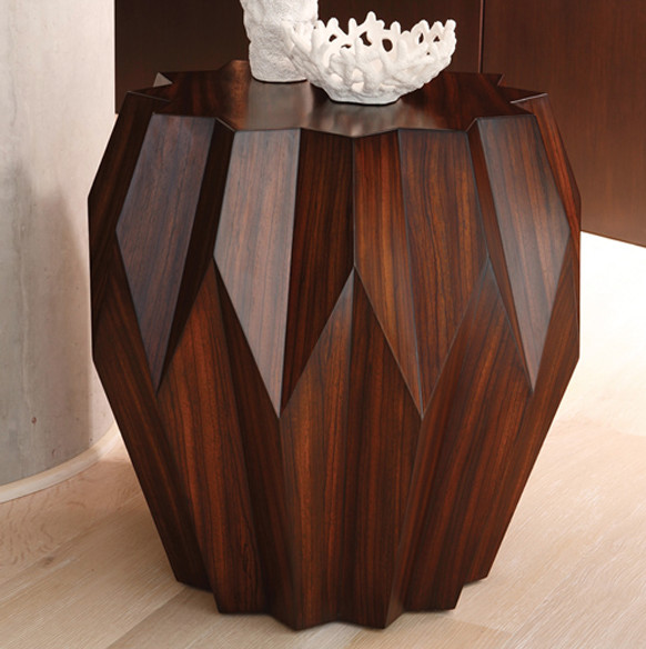 A wooden side table with a modern vase on it.