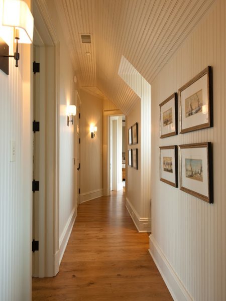 Sconces illuminate artwork in the hallway 
