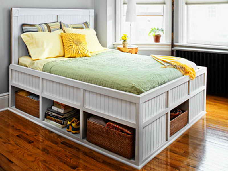 A space-saving bedroom with a white bed and storage drawers.