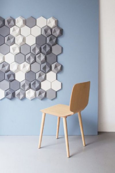 A chair positioned in front of a faceted wall of hexagons.