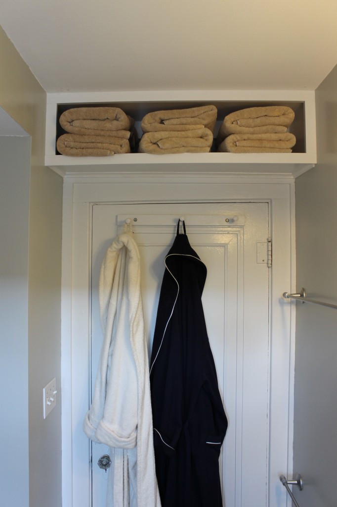 A space-saving bathroom with towels hanging on the wall.