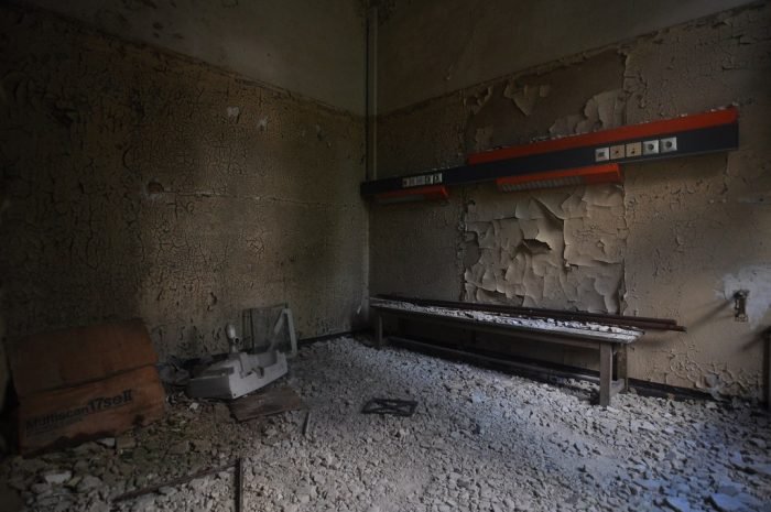 An abandoned room with a bench and a wall in Germany.