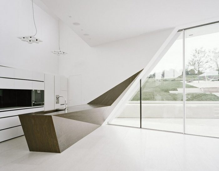 A faceted white kitchen with a wooden counter top.