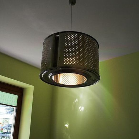 An upcycled light fixture hanging from a ceiling in a room with green walls.
