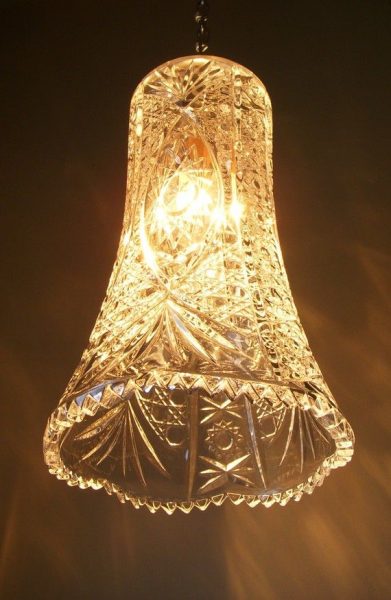An upcycled glass bell hanging from a light fixture.