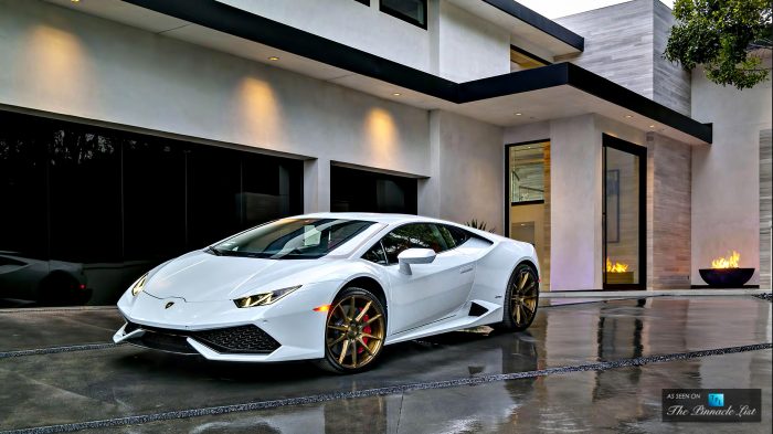 A stunning white Lamborghini Huracan is parked in front of a residence.