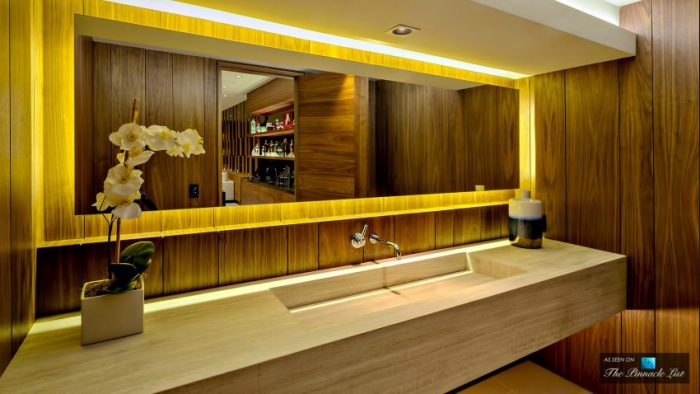 A stunning residence with a wooden sink and yellow lighting in the bathroom.