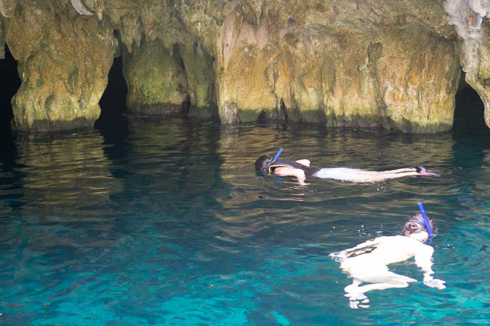 Two people snorkel underwater in a Central American cave.