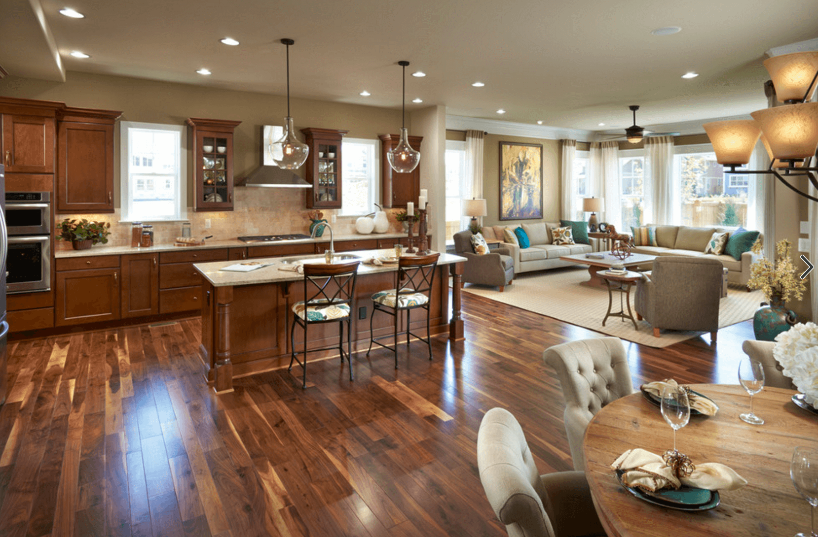 An open floor plan kitchen with a dining table and chairs.