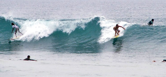 A group of surfers riding a wave in Sri Lanka.