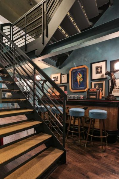 Johnny Depp's Penthouse features a stairway leading to a bar with blue stools.