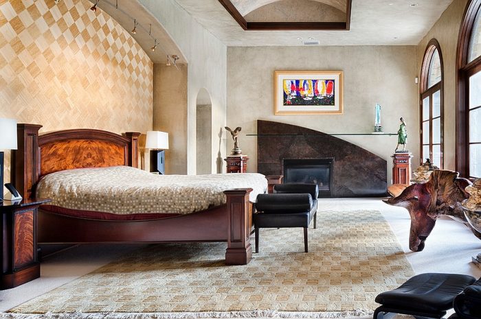 A Mediterranean-style bedroom with a bed and a fireplace.