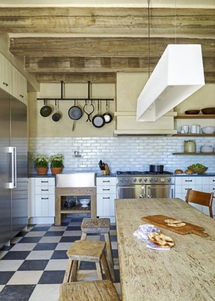 A kitchen with wooden beams and a Mediterranean-style checkered floor.
