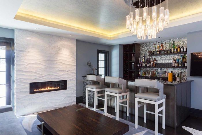 A modern home bar with a fireplace and bar stools.