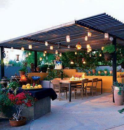An outdoor dining area with a table, chairs, and a fireplace.