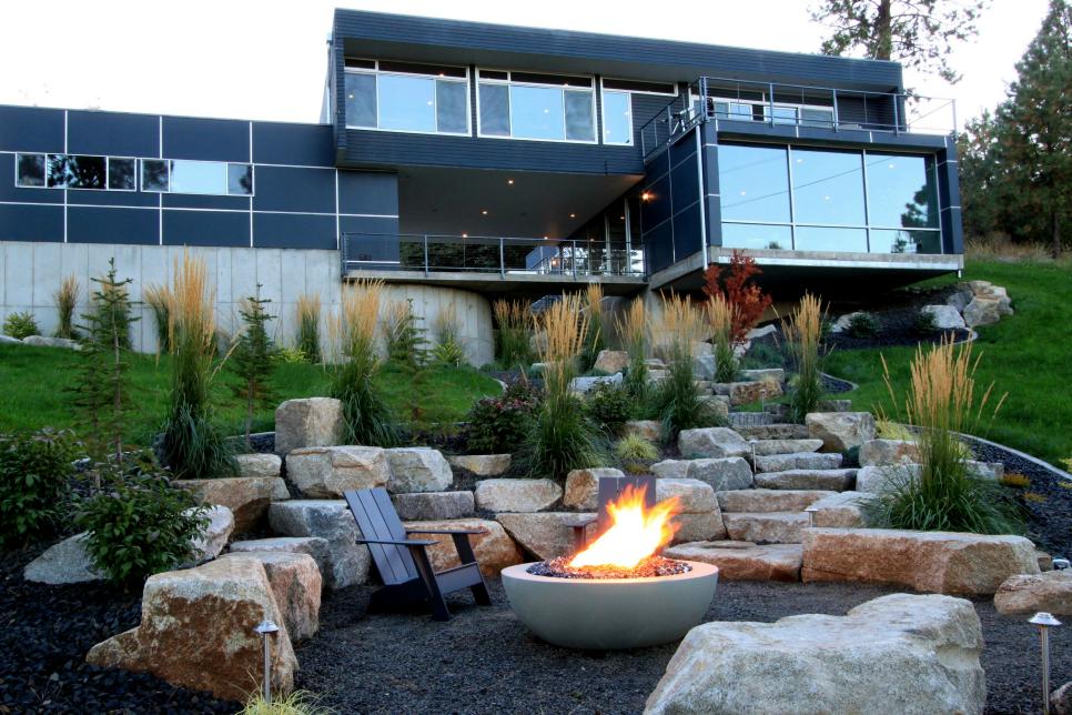 A modern home with a fireplace in the yard.