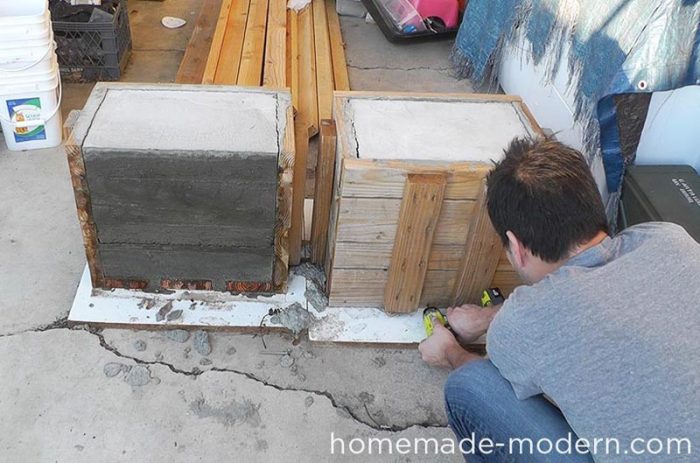 A man is DIY-ing with concrete blocks.