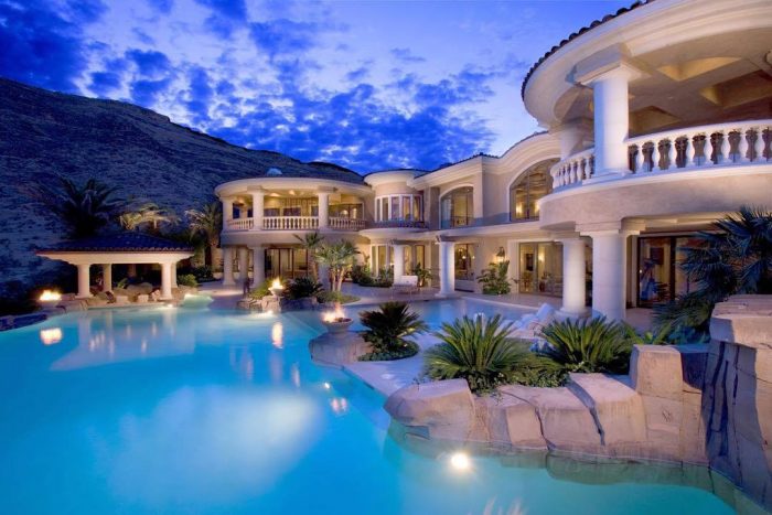 A luxurious mansion with a pool at dusk.