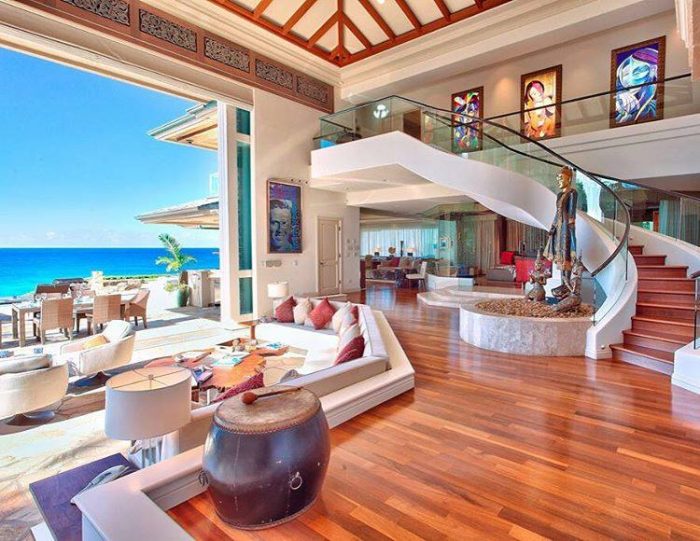 A luxurious living room with a staircase leading to the ocean.