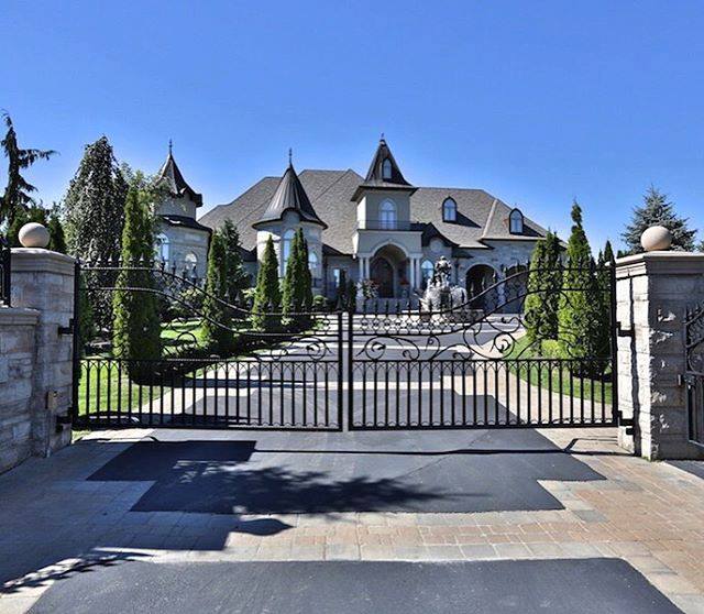 A gated entrance to a luxurious mansion.