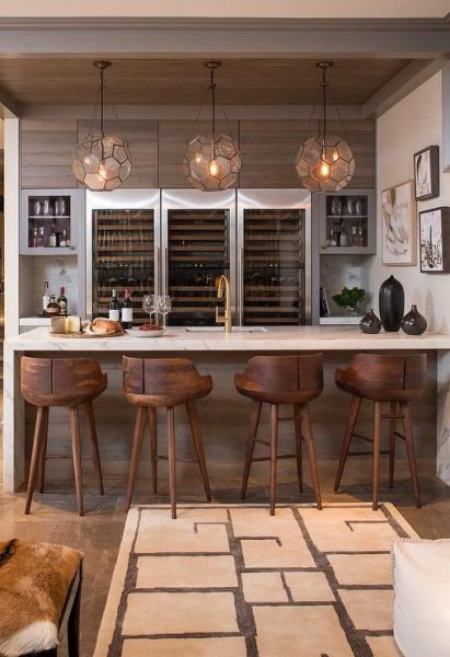 A modern kitchen with a home bar and stools.