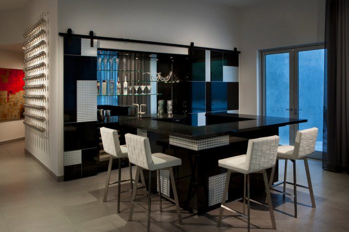 A home bar with modern black stools.
