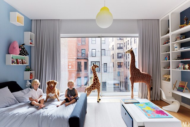 A child's room with giraffes and bookshelves.