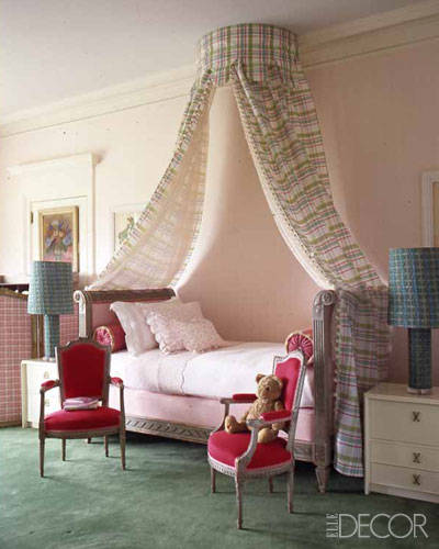 Pink child's bedroom with canopy bed and chairs.