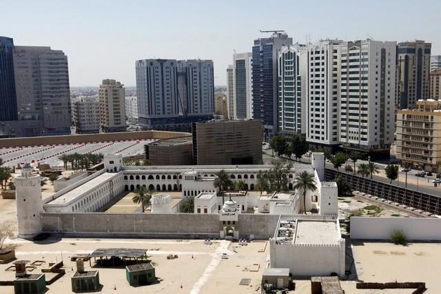 An aerial view of Abu Dhabi with buildings and a mosque.