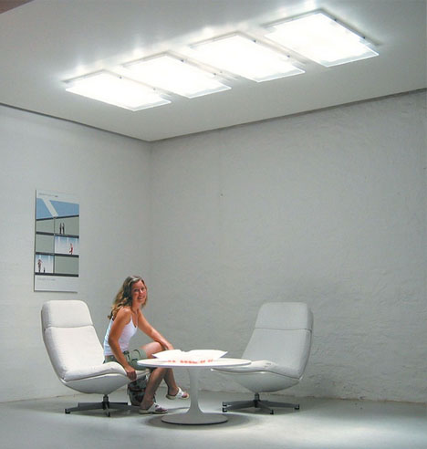 A woman sitting at a table in a windowless room.