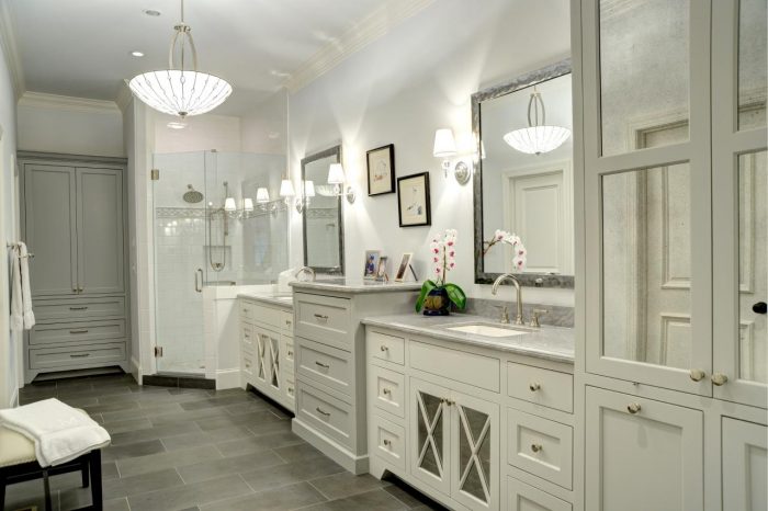 A bathroom with two sinks, a mirror, and gray floors.