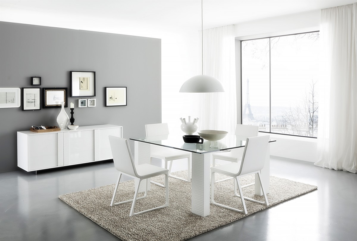 A modern dining room with gray floors and a white table and chairs.