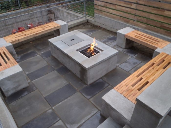 A concrete fire pit with gray floors and benches.