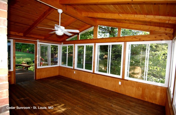 A sunlit sunroom with a wooden floor.
