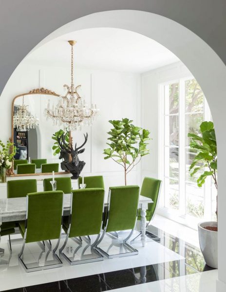 A dining room with Pantone's green chairs and an archway.