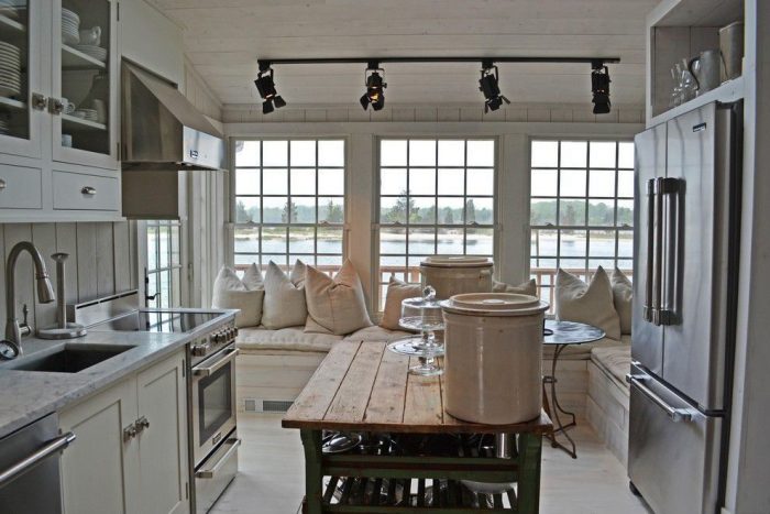 A kitchen with a large window and a table, featuring poised taupe accents.