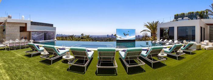 The lavish 924 Bel Air Rd mansion features a pool and lawn chairs.