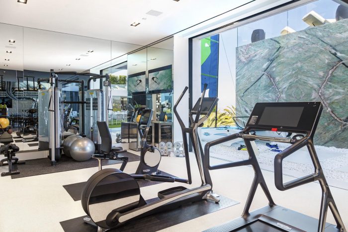 A gym room with exercise equipment and mirrors located at 924 Bel Air Rd.