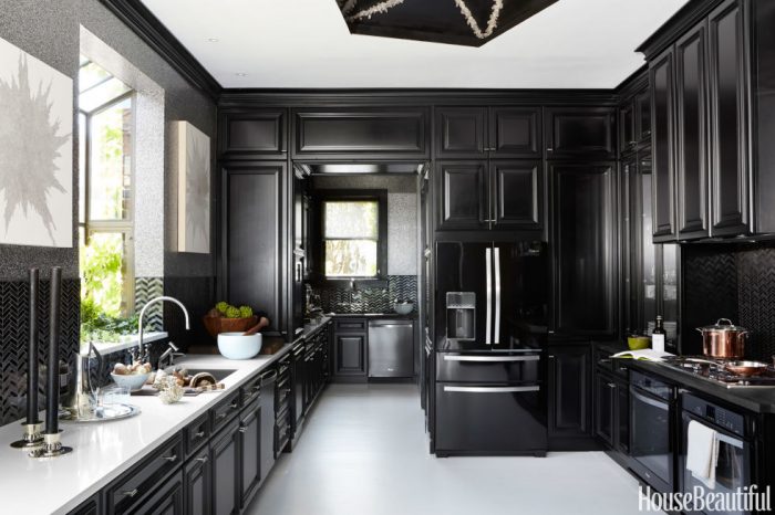 This bold black kitchen features white floors and countertops. Indeed, a dramatic kitchen