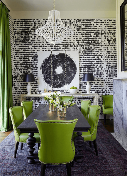 A dining room showcasing 2017 interior trends with green chairs and a black and white wallpaper.