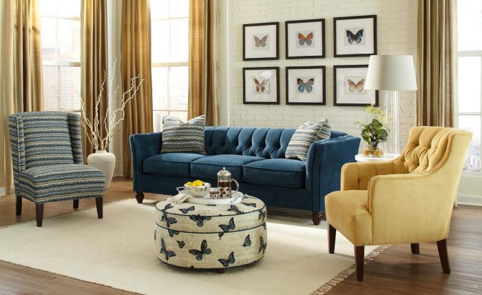 A living room with a blue couch and yellow chairs showcases 2017 interior trends.