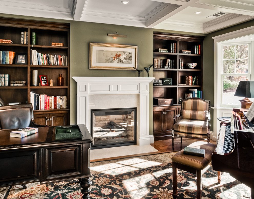 A cozy home office with a fireplace and bookshelves.
