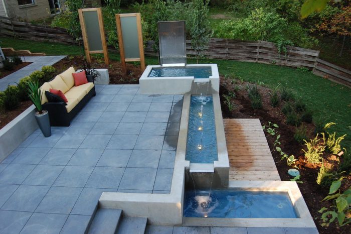 A modern patio with a water feature and a dog in it.