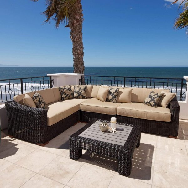 A modern patio furniture set on a patio overlooking the ocean.
