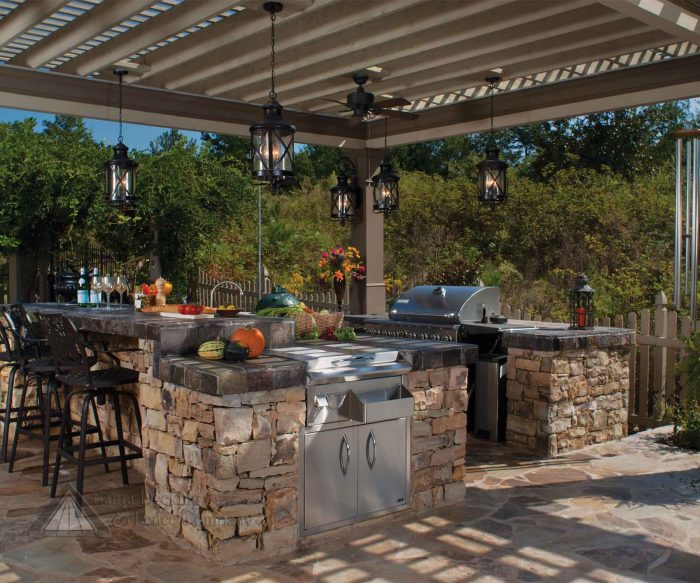 A modern outdoor kitchen with a grill on a patio.