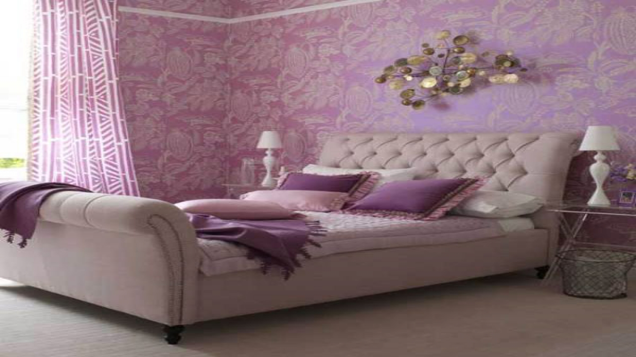 A bedroom with trendy purple wallpaper and a comfy bed.